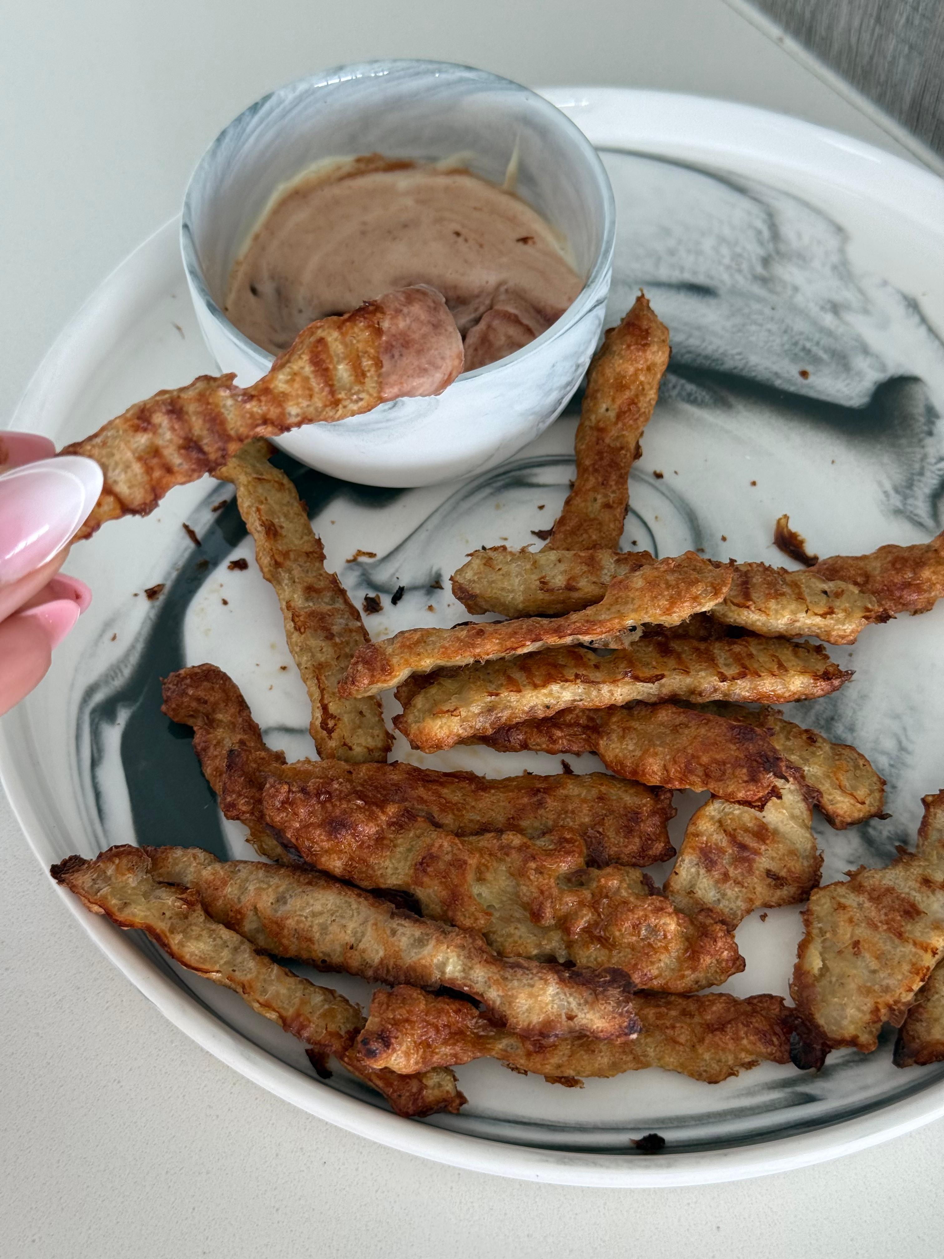 Crispy baked chicken fries on a marble plate with dipping sauce